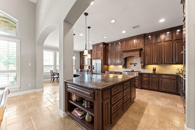 74 Spincaster Dr, Spring, TX 77389 - kitchen with appliances with stainless steel finishes, arched walkways, stone tile flooring, open shelves, and hanging light fixtures
