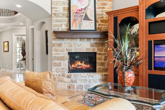 74 Spincaster Dr, Spring, TX 77389 - living room featuring a stone fireplace, ornamental molding, arched walkways, and recessed lighting