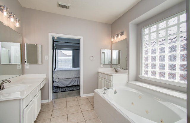 12807 Sienna Trails Dr, Tomball, TX 77377 - ensuite bathroom featuring healthy amount of natural light, a whirlpool tub, two vanities, and tile patterned floors
