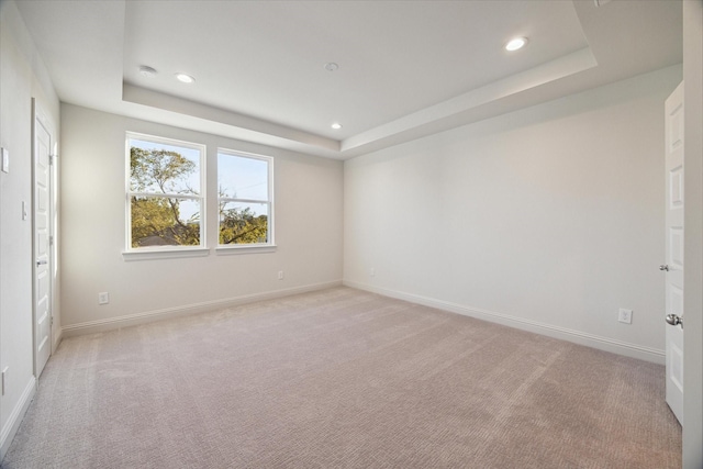 1805 Mills St, Houston, TX 77026 - unfurnished bedroom with a tray ceiling, recessed lighting, light carpet, and baseboards