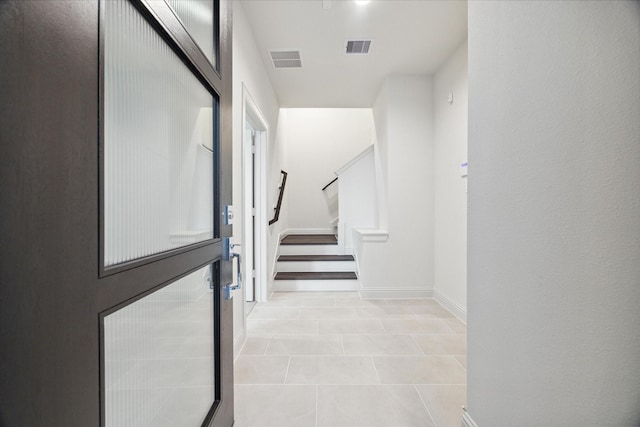 1805 Mills St, Houston, TX 77026 - hall featuring light tile patterned floors, baseboards, and stairway