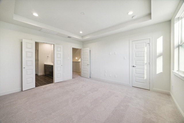 1805 Mills St, Houston, TX 77026 - unfurnished bedroom with a tray ceiling, carpet flooring, recessed lighting, baseboards, and ensuite bath