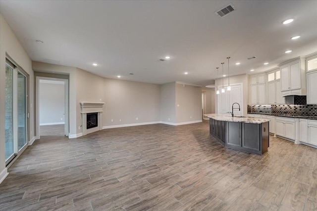 7563 Congress Trail Way, Porter, TX 77365 - kitchen with a sink, backsplash, wood finished floors, and recessed lighting