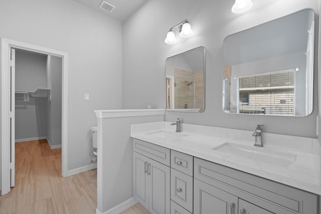 146 S Star Ridge Cir, The Woodlands, TX 77382 - bathroom featuring toilet, a tile shower, double vanity, baseboards, and a walk in closet