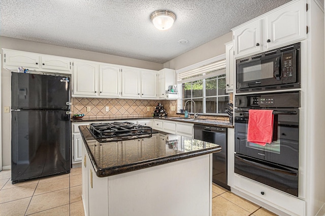 1826 Concho River Ct, Sugar Land, TX 77478 - kitchen featuring black appliances, a warming drawer, white cabinetry, light tile patterned floors, and a textured ceiling