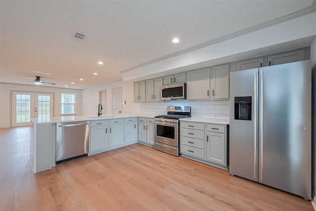 6023 Viking Dr, Houston, TX 77092 - kitchen featuring stainless steel appliances, a sink, a peninsula, light countertops, and light wood-style floors