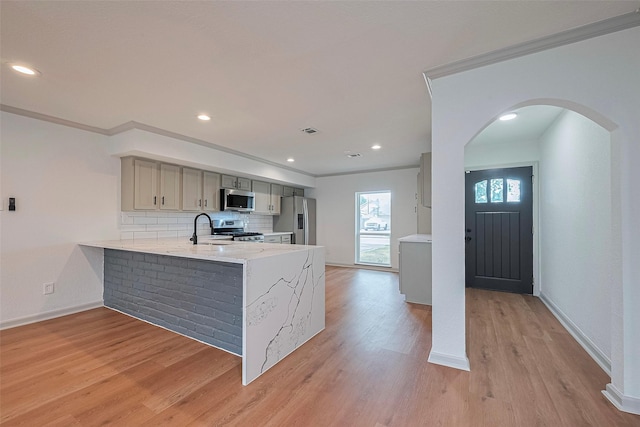 6023 Viking Dr, Houston, TX 77092 - kitchen featuring appliances with stainless steel finishes, a sink, a peninsula, light wood-style floors, and baseboards