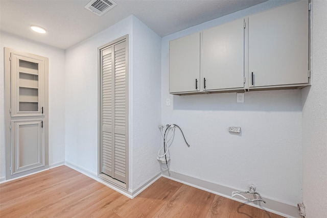 6023 Viking Dr, Houston, TX 77092 - laundry room featuring light wood-style floors, baseboards, and cabinet space
