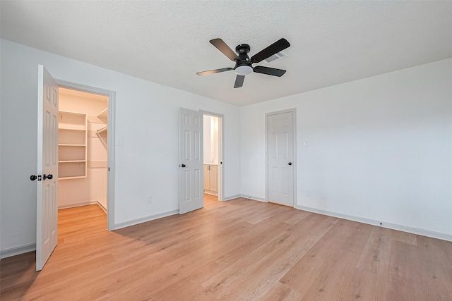 6023 Viking Dr, Houston, TX 77092 - unfurnished bedroom featuring light wood-style floors, baseboards, a closet, a spacious closet, and ceiling fan