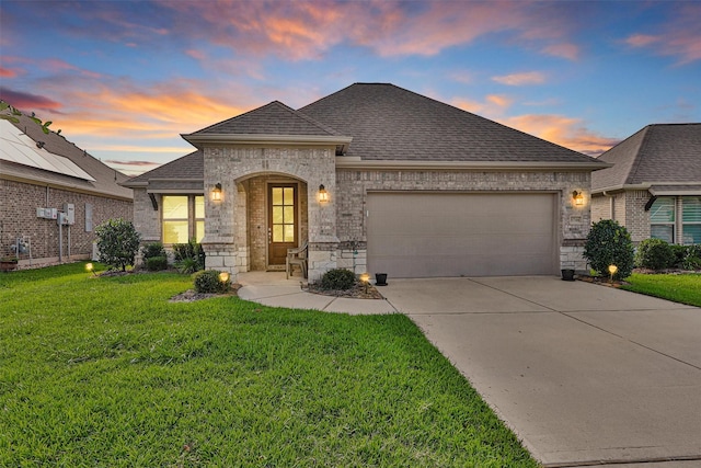 5746 Lakeside Villas Ct, Conroe, TX 77304 - french country home with an attached garage, concrete driveway, a front lawn, and a shingled roof