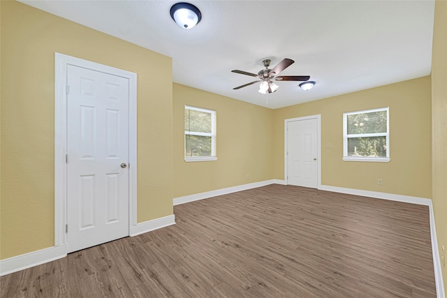 2406 W Elvinta St, Baytown, TX 77520 - empty room with wood finished floors, baseboards, and a ceiling fan
