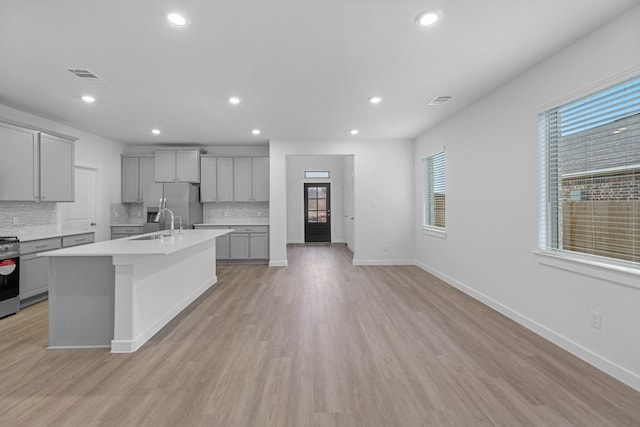 19380 Poppy Village Cir, Magnolia, TX 77355 - kitchen with gray cabinetry, appliances with stainless steel finishes, plenty of natural light, backsplash, and recessed lighting