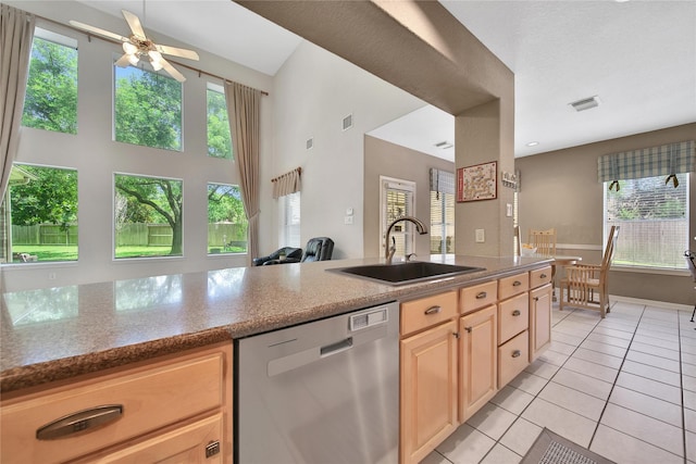 14414 Spanish River Ln, Cypress, TX 77429 - kitchen with stainless steel dishwasher, a sink, light brown cabinetry, light tile patterned flooring, and healthy amount of natural light