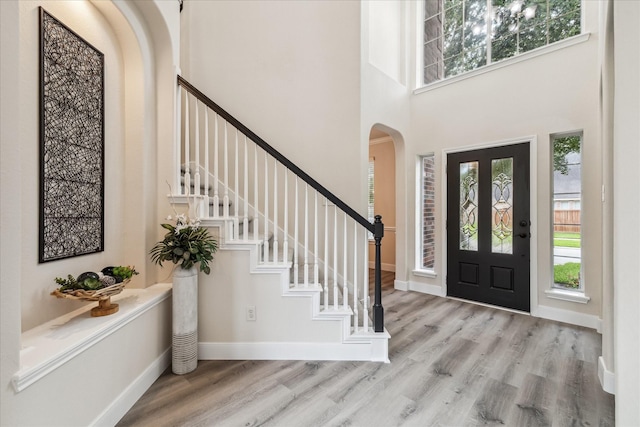 13411 SE Via Chianti Ln, Cypress, TX 77429 - foyer featuring arched walkways, a towering ceiling, wood finished floors, stairs, and baseboards