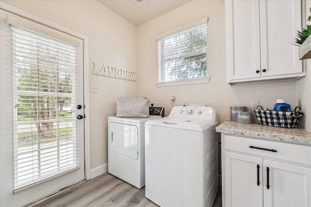 13411 SE Via Chianti Ln, Cypress, TX 77429 - laundry room featuring washing machine and clothes dryer, cabinet space, light wood-style flooring, and baseboards