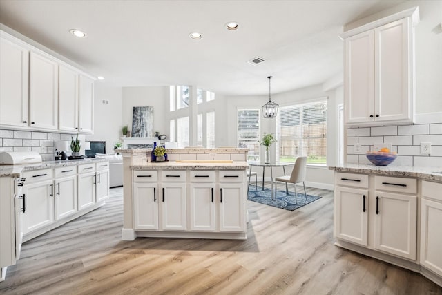 13411 SE Via Chianti Ln, Cypress, TX 77429 - kitchen featuring backsplash, recessed lighting, light wood finished floors, and white cabinetry