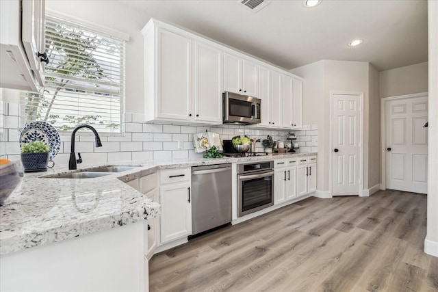13411 SE Via Chianti Ln, Cypress, TX 77429 - kitchen with appliances with stainless steel finishes, a sink, white cabinets, and recessed lighting