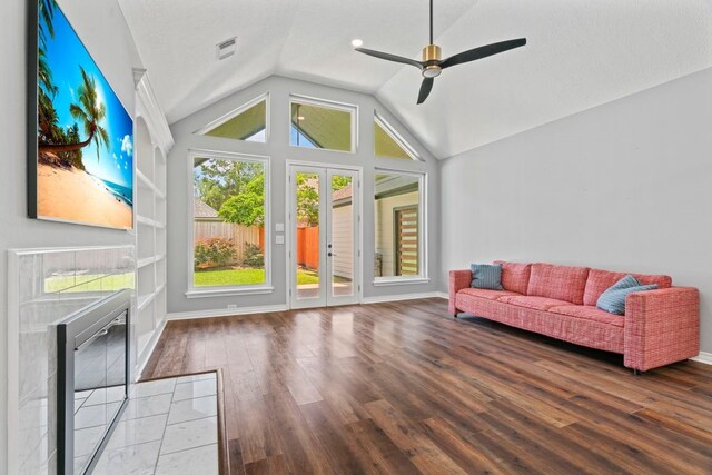 1806 Quiet Country Ct, Houston, TX 77345 - living area featuring french doors, wood finished floors, vaulted ceiling, a ceiling fan, and a tiled fireplace