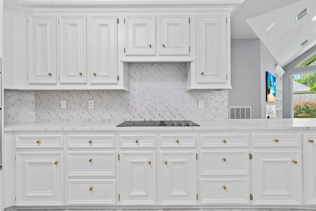 1806 Quiet Country Ct, Houston, TX 77345 - kitchen with white cabinets, backsplash, light stone counters, and black electric stovetop