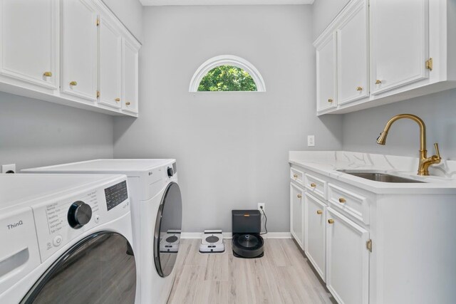 1806 Quiet Country Ct, Houston, TX 77345 - washroom with cabinet space, washing machine and clothes dryer, light wood-style flooring, and baseboards