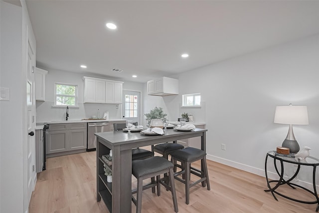 7406 Valeda Dr, Deer Park, TX 77536 - kitchen with dishwasher, light wood-style floors, recessed lighting, white cabinetry, and baseboards