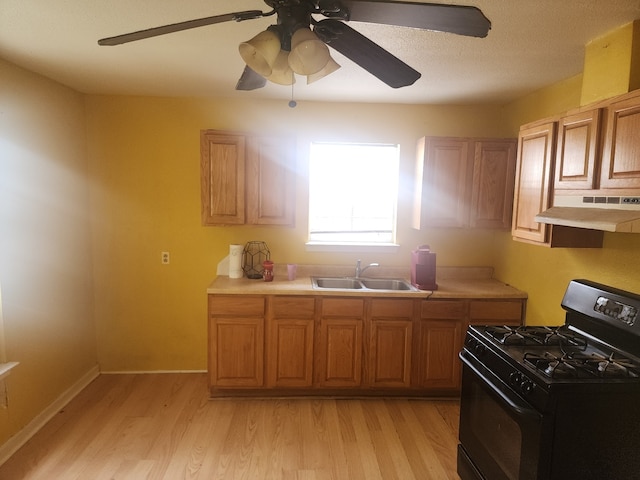 2172 W Laurel, San Antonio, TX 78201 - kitchen with black gas range oven, under cabinet range hood, a sink, and light countertops