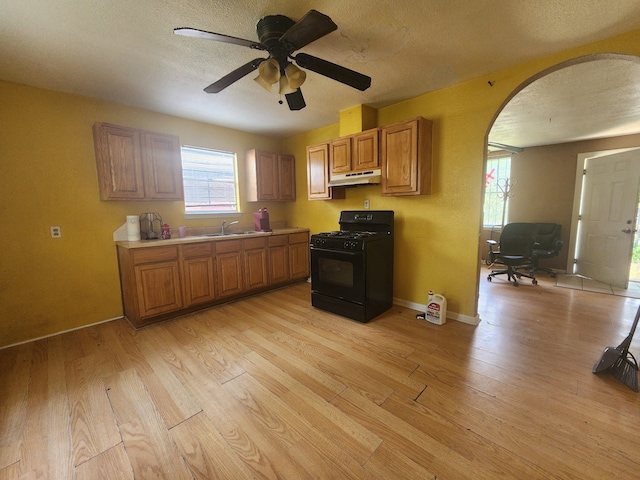 2172 W Laurel, San Antonio, TX 78201 - kitchen featuring black gas range, under cabinet range hood, light wood finished floors, light countertops, and a textured ceiling