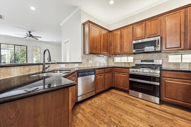 5308 Larkin St Unit B, Houston, TX 77007 - kitchen featuring stainless steel appliances, a sink, dark stone counters, light wood-style flooring, and backsplash