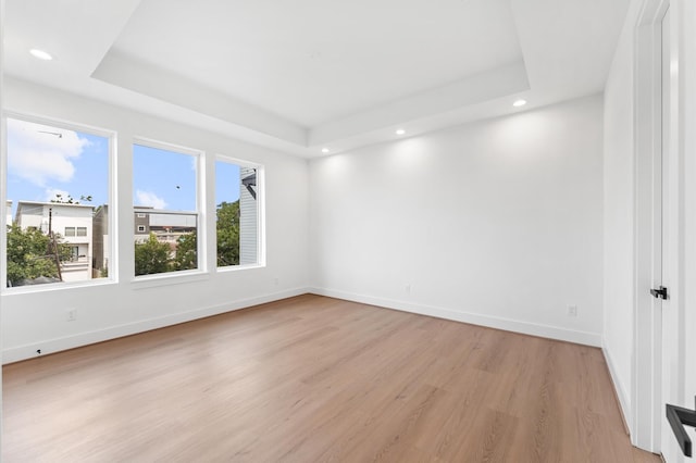 3209 Baer St Unit B, Houston, TX 77020 - empty room with a tray ceiling, light wood-style flooring, and recessed lighting