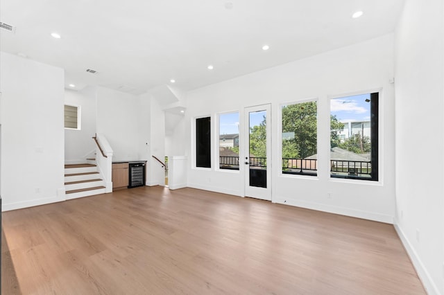 3209 Baer St Unit B, Houston, TX 77020 - unfurnished living room featuring beverage cooler, recessed lighting, light wood-type flooring, and stairs
