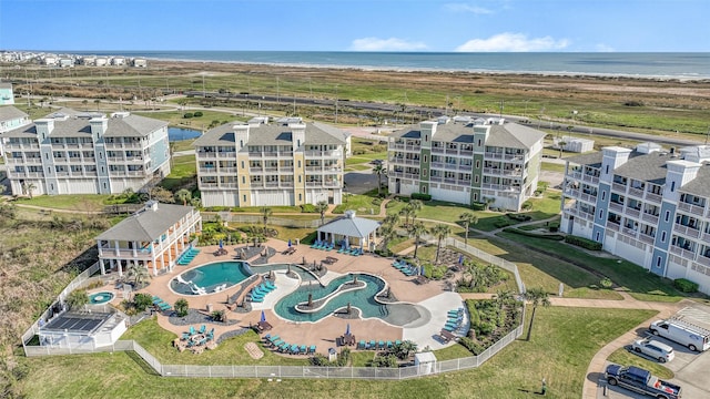 3903 Evening Primrose Dr, Galveston, TX 77554 - drone / aerial view of a pool area, a nearby body of water, and apartment complex