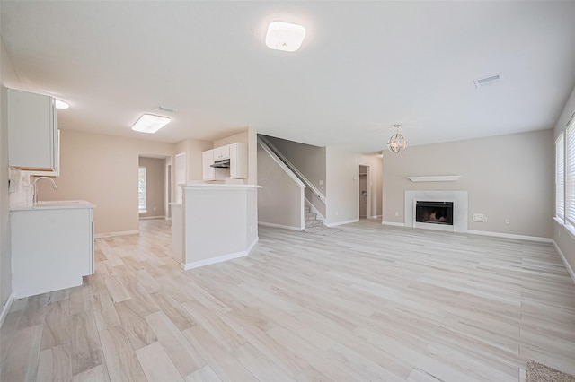 16502 N Glade Dr, Houston, TX 77073 - unfurnished living room with a sink, plenty of natural light, baseboards, and stairway