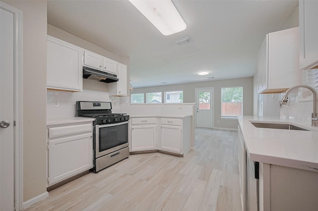 16502 N Glade Dr, Houston, TX 77073 - kitchen featuring gas range, a sink, under cabinet range hood, a peninsula, and light wood-style floors
