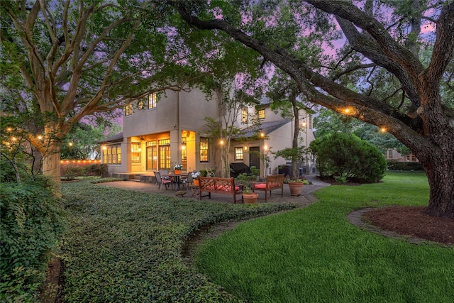 3502 Underwood St, Houston, TX 77025 - back of house at dusk with a yard and a patio