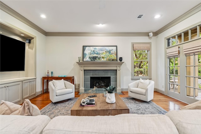 3502 Underwood St, Houston, TX 77025 - living room with crown molding, wood finished floors, a tiled fireplace, and recessed lighting