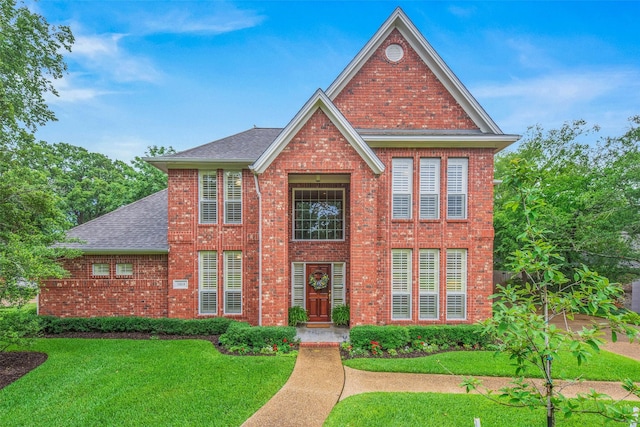 3008 Cochise Ct, College Station, TX 77845 - view of front of house featuring brick siding, roof with shingles, and a front yard
