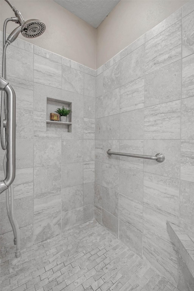 3008 Cochise Ct, College Station, TX 77845 - bathroom with a tile shower and a textured ceiling