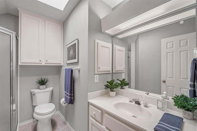 3008 Cochise Ct, College Station, TX 77845 - full bathroom with vanity, toilet, a shower with door, a skylight, and tile patterned flooring