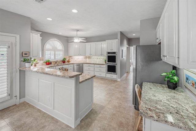 3008 Cochise Ct, College Station, TX 77845 - kitchen with a peninsula, stainless steel appliances, white cabinetry, and recessed lighting