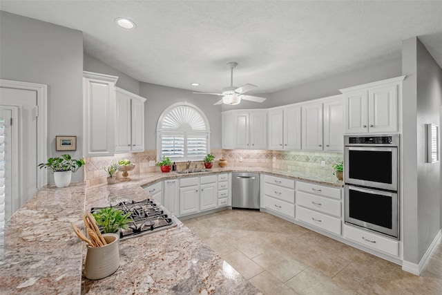 3008 Cochise Ct, College Station, TX 77845 - kitchen with appliances with stainless steel finishes, a sink, tasteful backsplash, white cabinetry, and recessed lighting