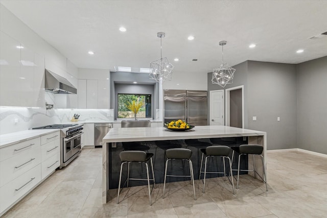 2411 Oakbank Dr, Houston, TX 77339 - kitchen with premium appliances, modern cabinets, wall chimney range hood, a chandelier, and white cabinetry