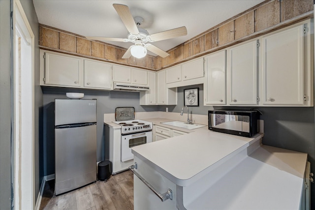 2411 Oakbank Dr, Houston, TX 77339 - kitchen with freestanding refrigerator, white range with electric stovetop, under cabinet range hood, black microwave, and a sink