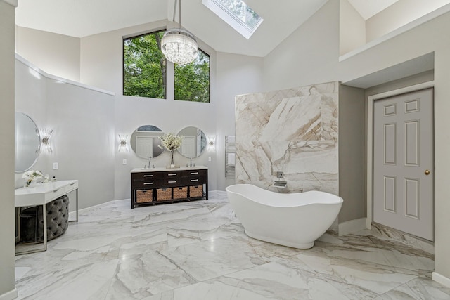 2411 Oakbank Dr, Houston, TX 77339 - bathroom featuring high vaulted ceiling, a chandelier, a skylight, marble tiled flooring, and a soaking tub