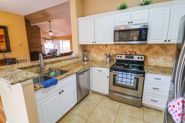 13555 Portobello Dr, Houston, TX 77083 - kitchen with stainless steel appliances, a sink, vaulted ceiling, a peninsula, and decorative backsplash
