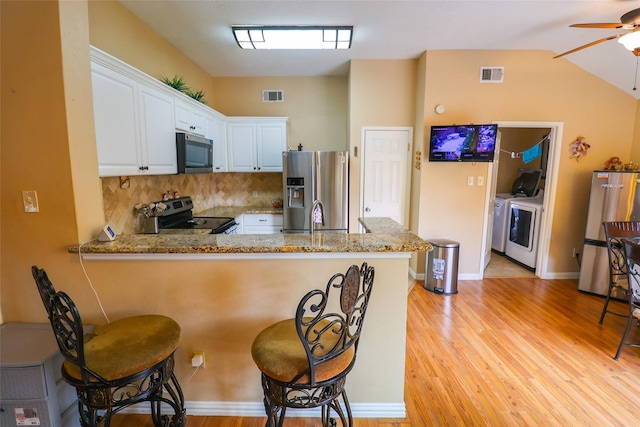 13555 Portobello Dr, Houston, TX 77083 - kitchen with appliances with stainless steel finishes, washer and dryer, a peninsula, a ceiling fan, and light stone counters