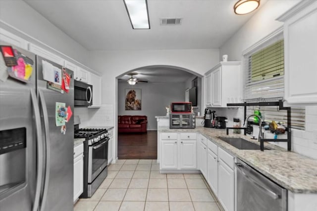 8731 Majesticbrook Dr, Houston, TX 77095 - kitchen with stainless steel appliances, a sink, a ceiling fan, light tile patterned floors, and white cabinets
