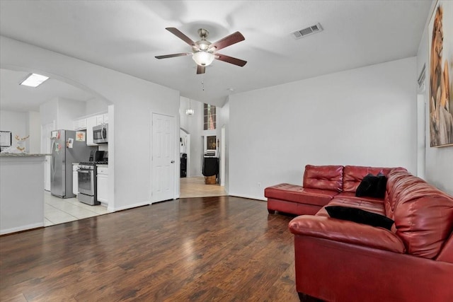 8731 Majesticbrook Dr, Houston, TX 77095 - living area featuring a ceiling fan, arched walkways, light wood-type flooring, and baseboards