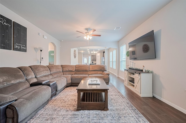 1214 Red Hills Dr, Rosharon, TX 77583 - living area featuring a ceiling fan, arched walkways, dark wood-type flooring, and baseboards