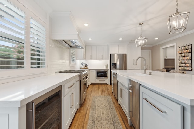 2502 Briarbrook Dr, Houston, TX 77042 - kitchen featuring premium range hood, beverage cooler, high end stainless steel range, a chandelier, and a sink