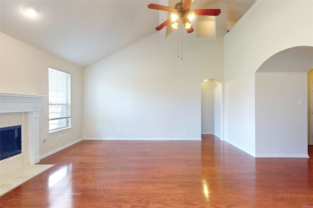 3606 Kilgore Ct, Manvel, TX 77578 - unfurnished living room with arched walkways, a ceiling fan, a fireplace, high vaulted ceiling, and wood finished floors